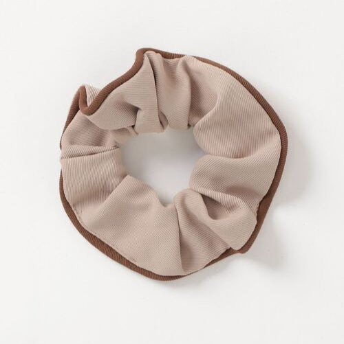 Beige scrunchie with brown trim on a white background