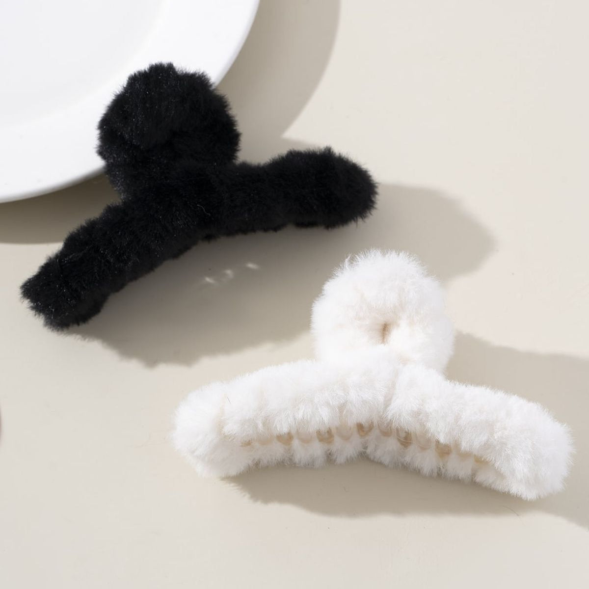Black and white fuzzy hair clip on a neutral background