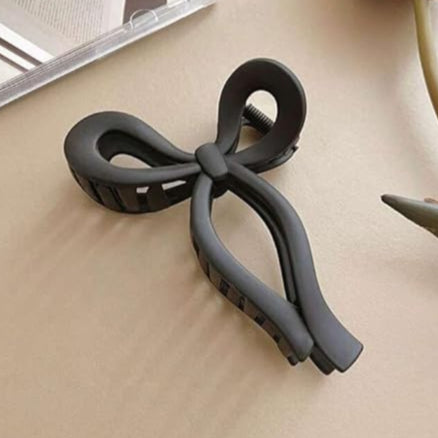 Black hair clip on a beige surface