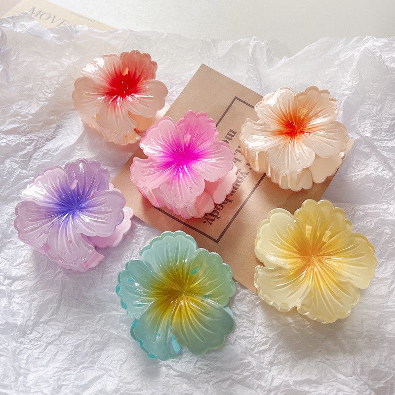 Set of colorful flower-shaped hair clips on a textured white surface