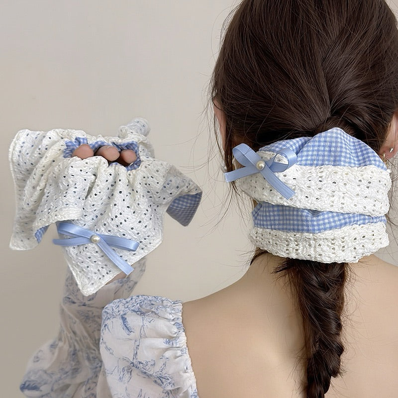 Woman with braided hair wearing decorative hair ties with bows and lace details.