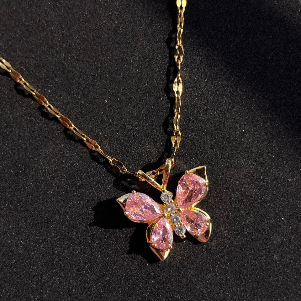 Butterfly-shaped pink gemstone necklace on a black background