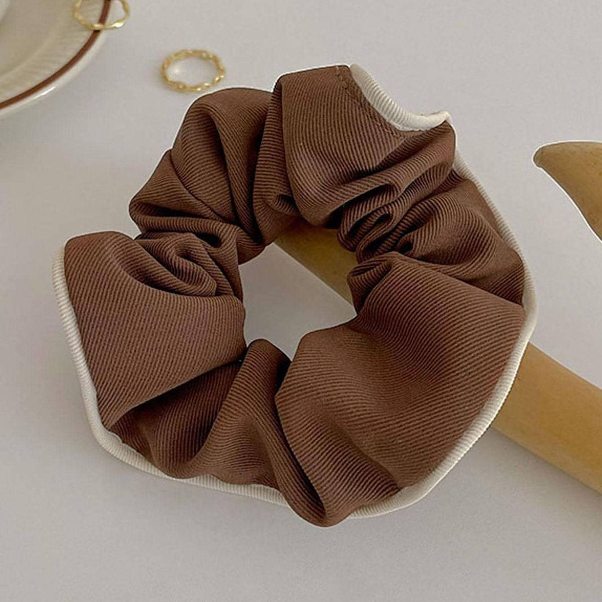 Brown scrunchie on a white plate with a light background