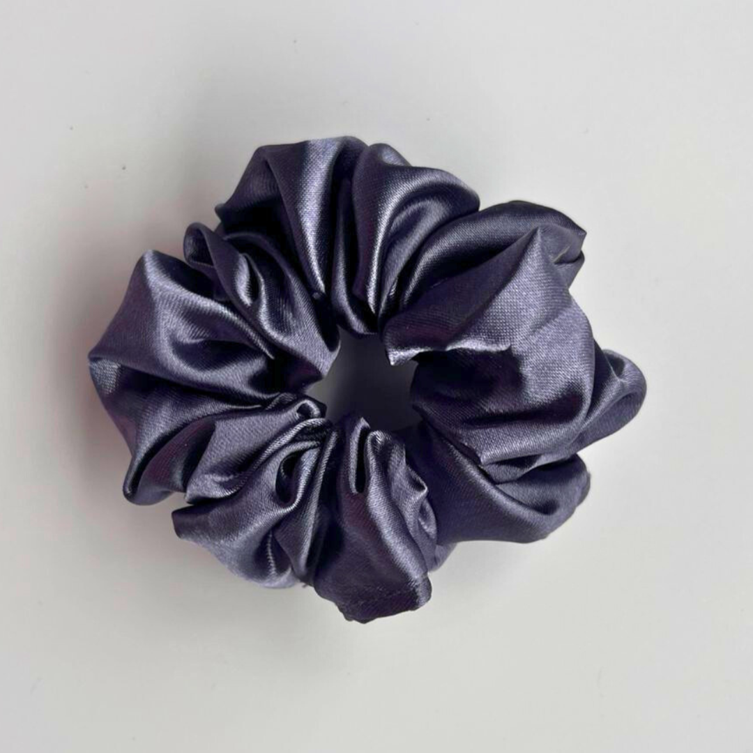 Navy blue satin scrunchie on a light gray background