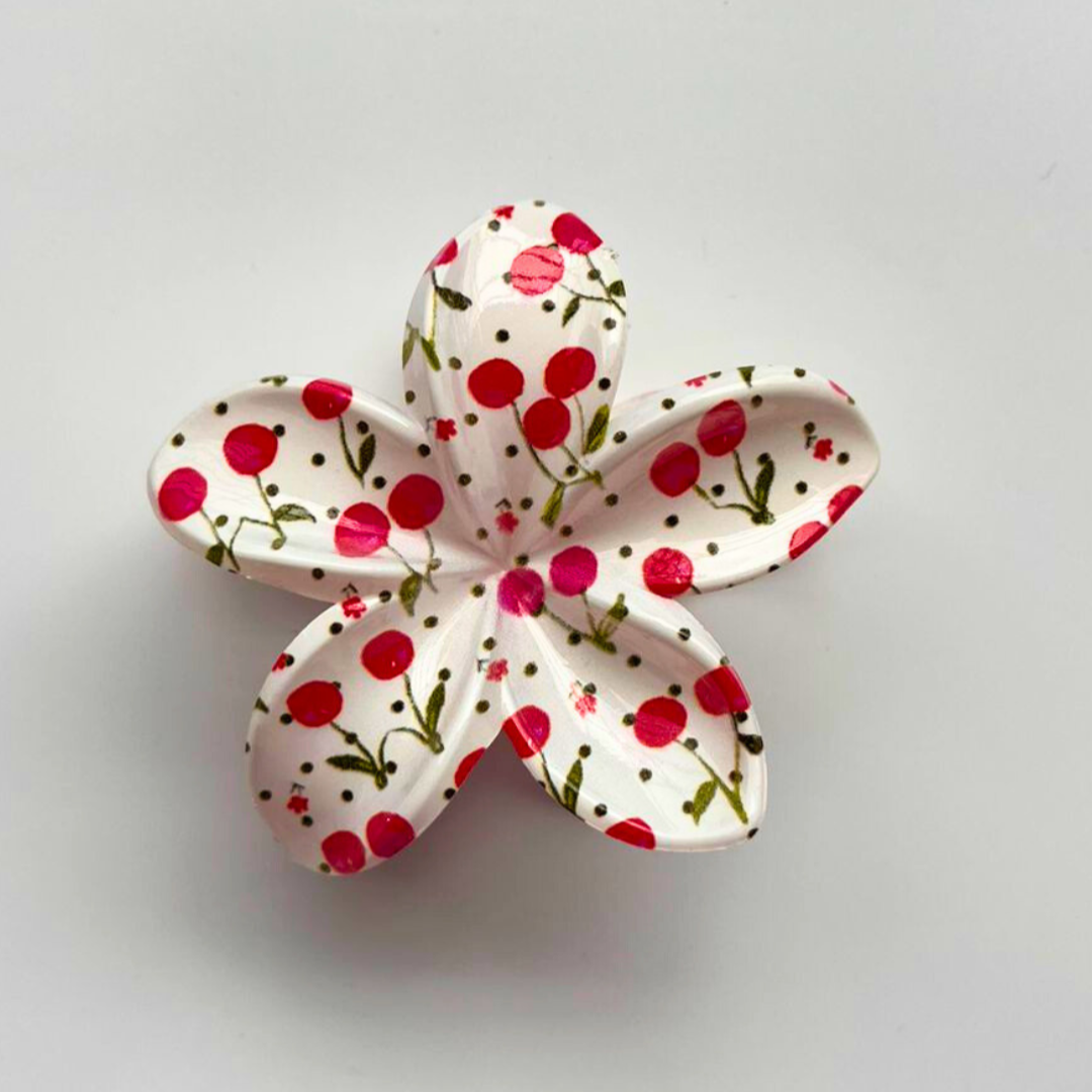 Floral ceramic flower with red and pink polka dot pattern on a white background
