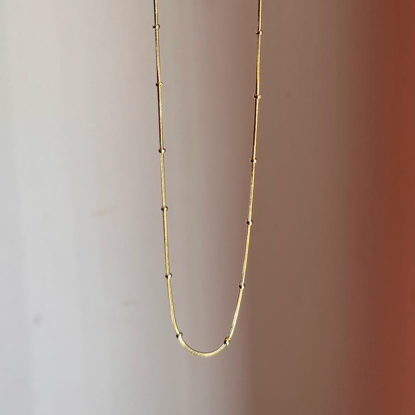 Gold necklace on a gradient background