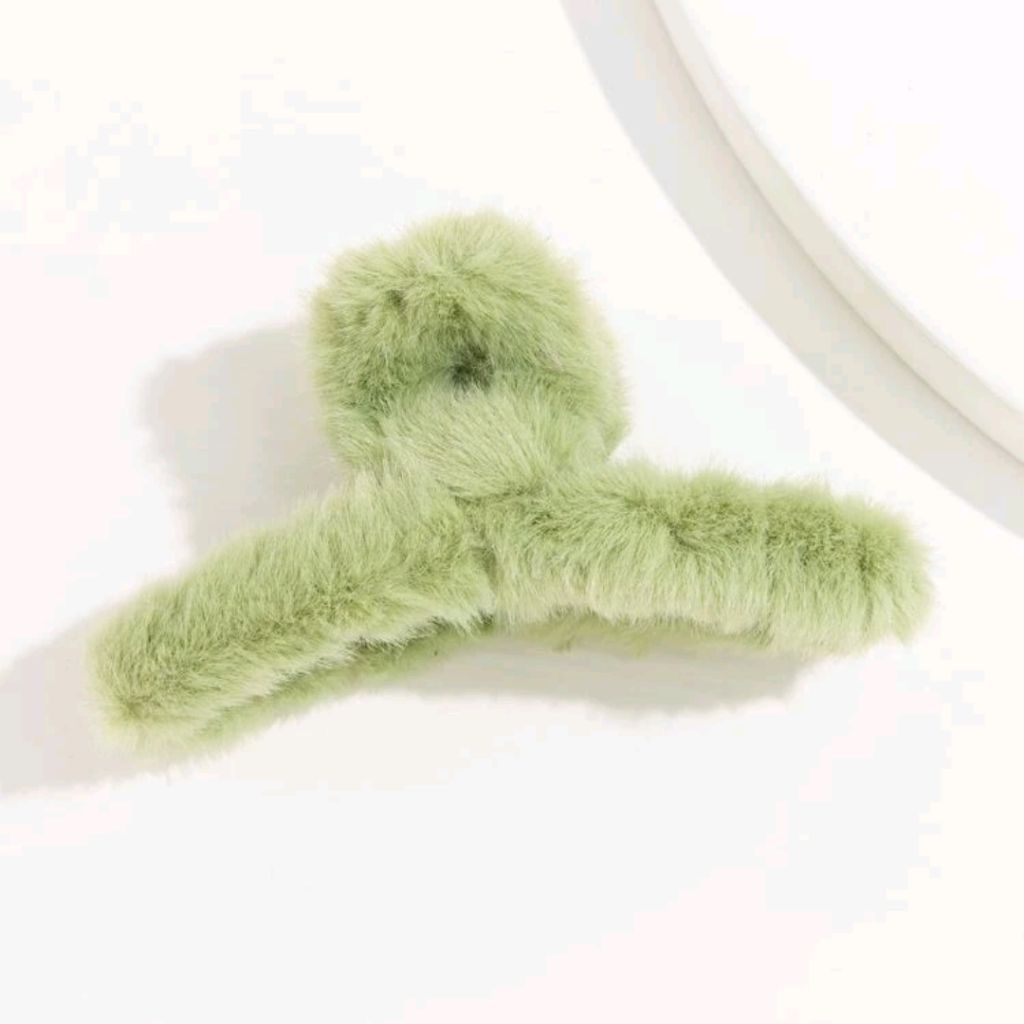 Green fluffy hair clip on a white background