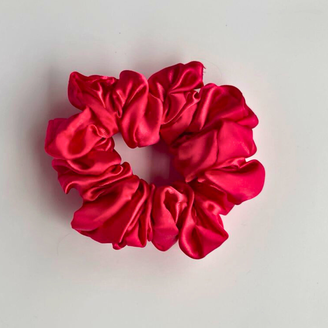 Red satin scrunchie on a light gray background