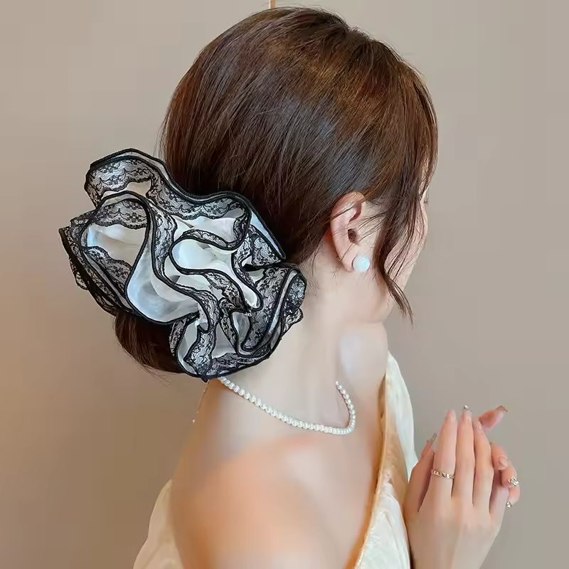 Woman wearing a black lace hair accessory with a blurred background