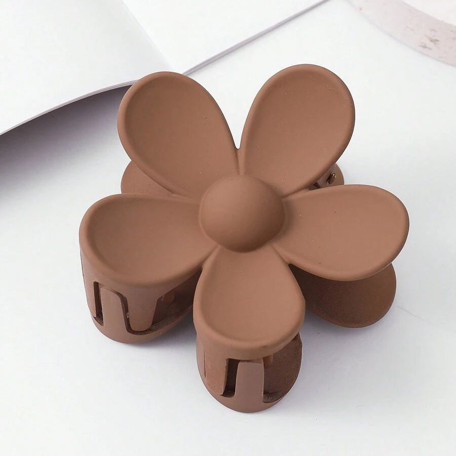 Brown flower-shaped hair clip on a white background