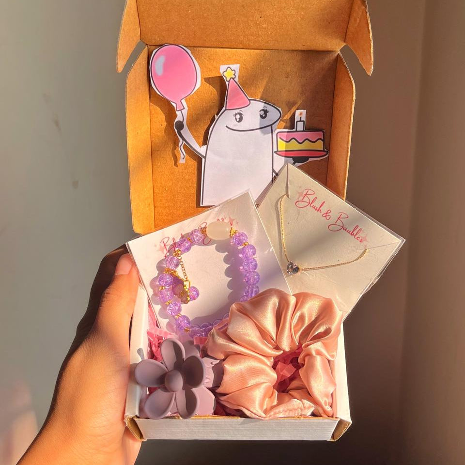 Box of hair accessories including a scrunchie, hair tie, and necklace with a cartoon character on a plain background.