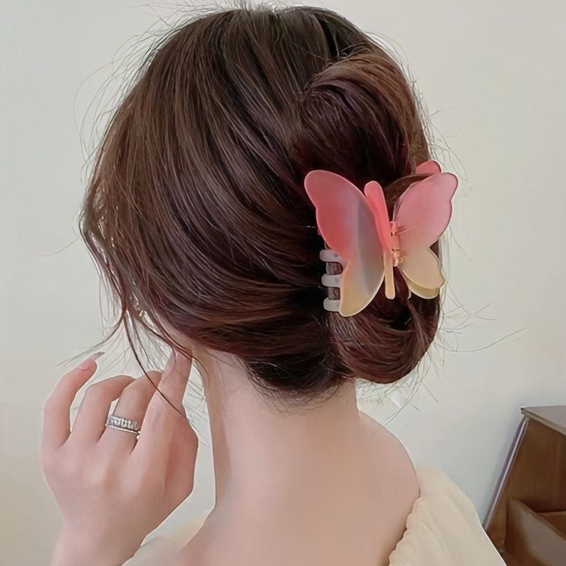 Person with a butterfly hair clip in their hair against a neutral background