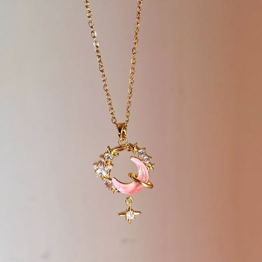 Gold necklace with a pink pendant on a gradient background