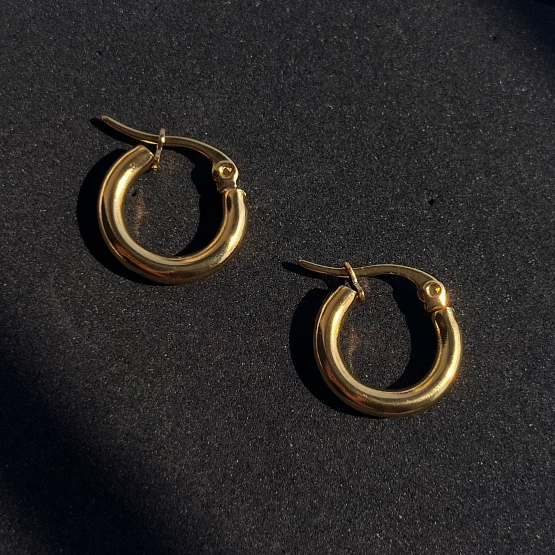 Gold hoop earrings on a black background