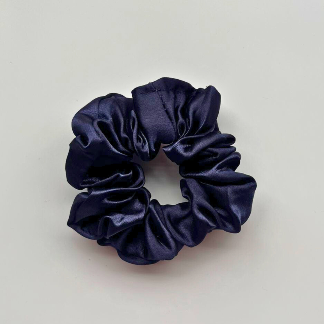Navy blue scrunchie on a light gray background