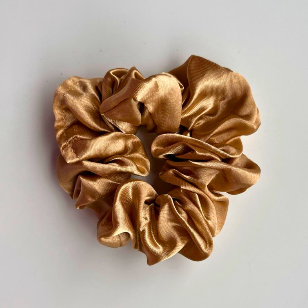 Gold scrunchie on a light gray background