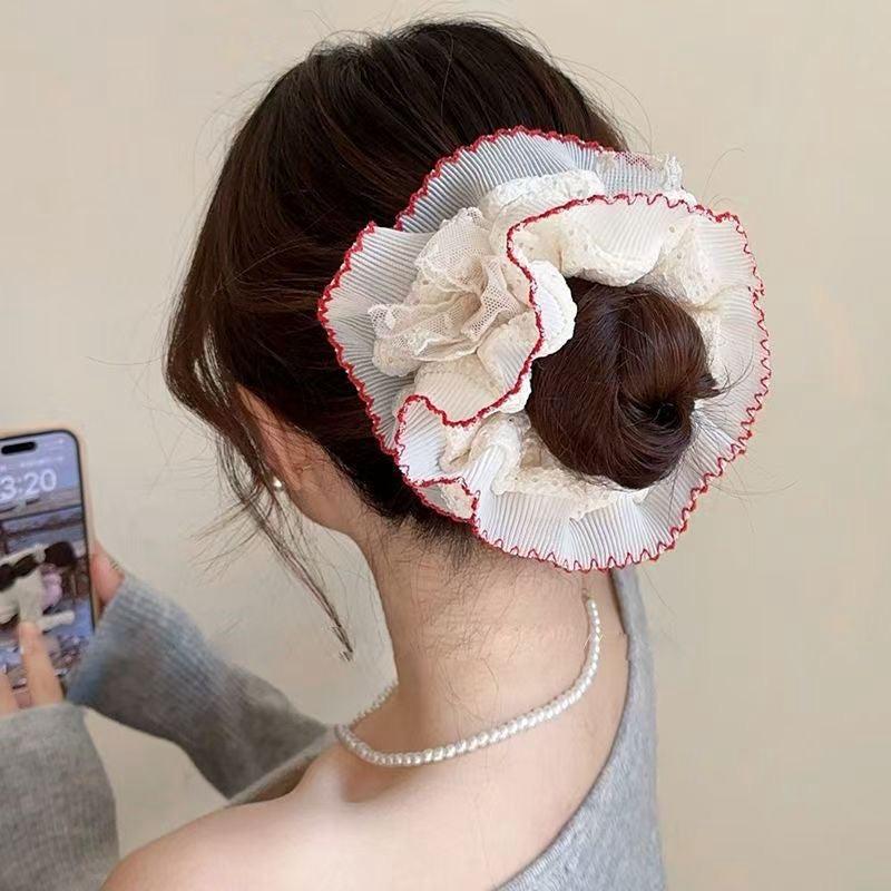 Woman with a decorative hair bun using a white floral hair accessory.