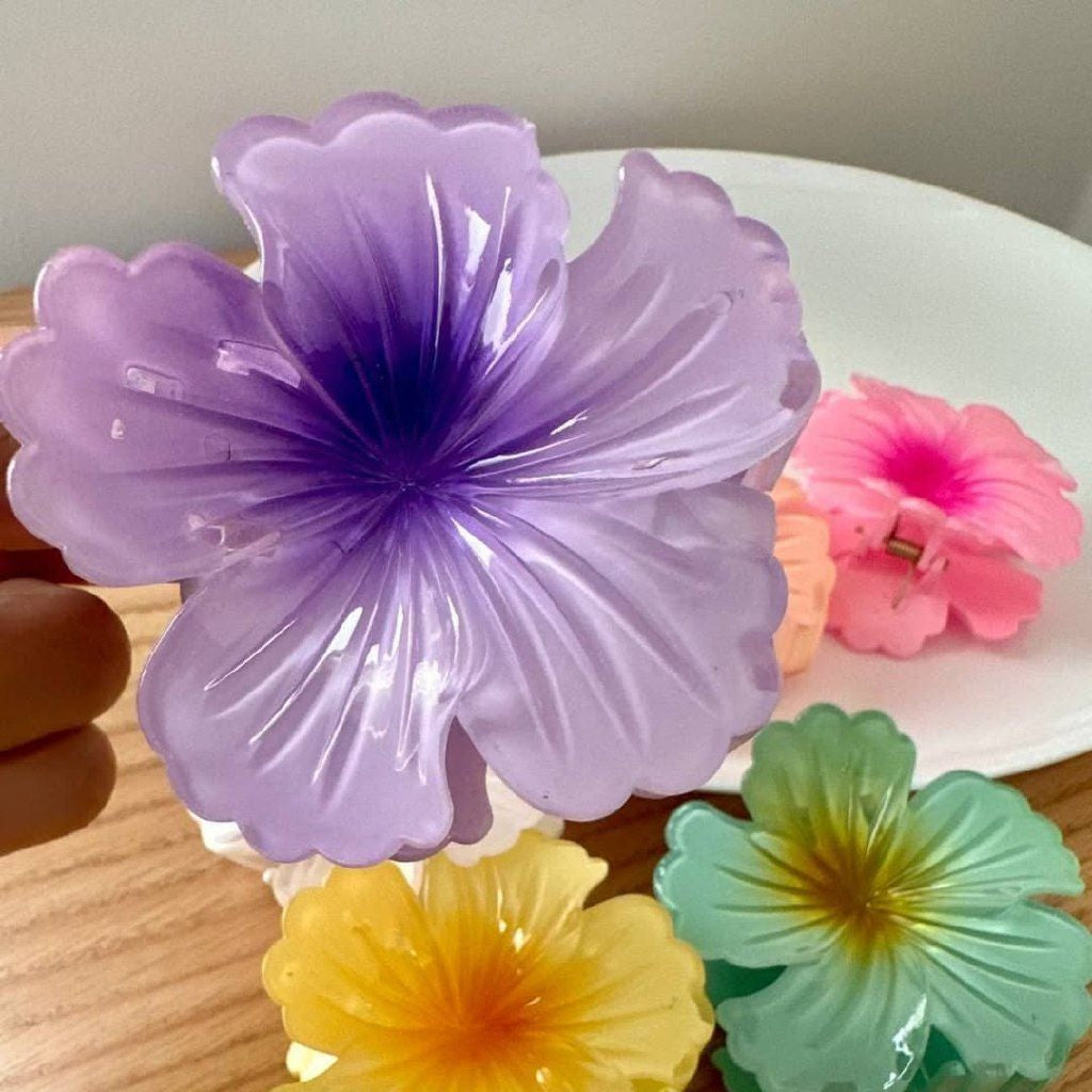 Colorful flower-shaped hair clips on a wooden surface