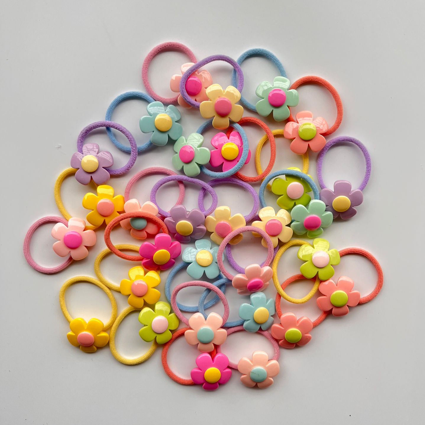 Colorful hair ties with floral designs on a gray background