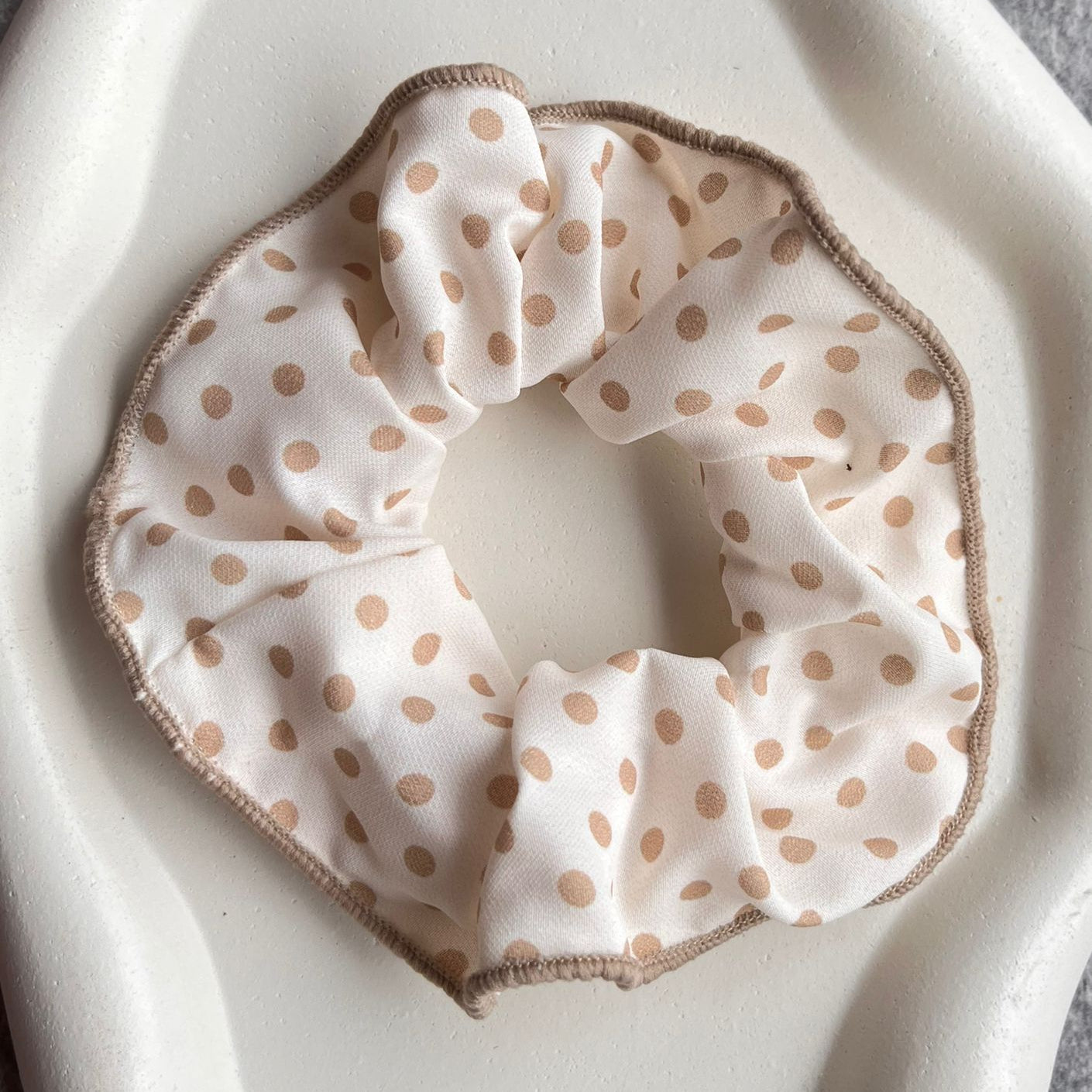 Polka dot scrunchie on a white surface