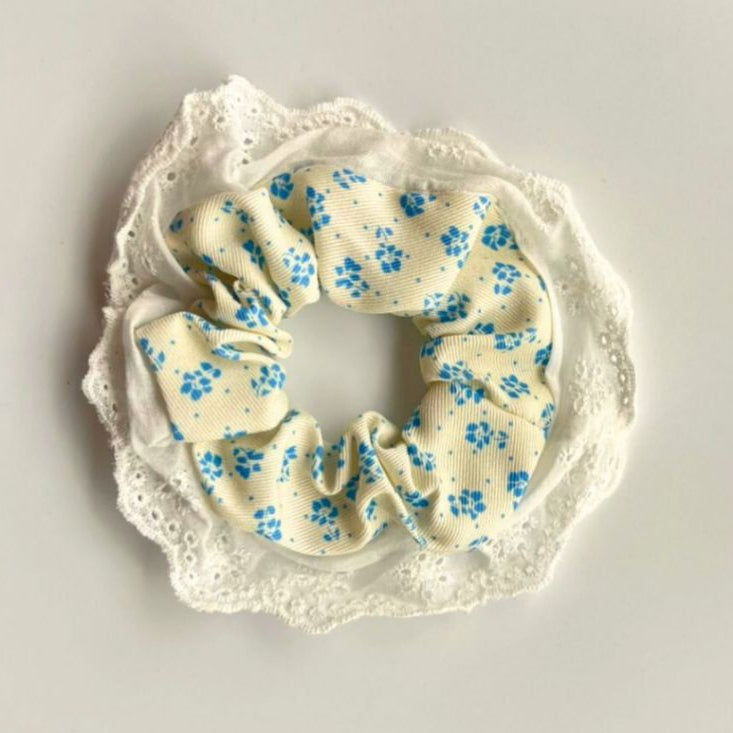Scrunchie with blue floral pattern on a white lace background