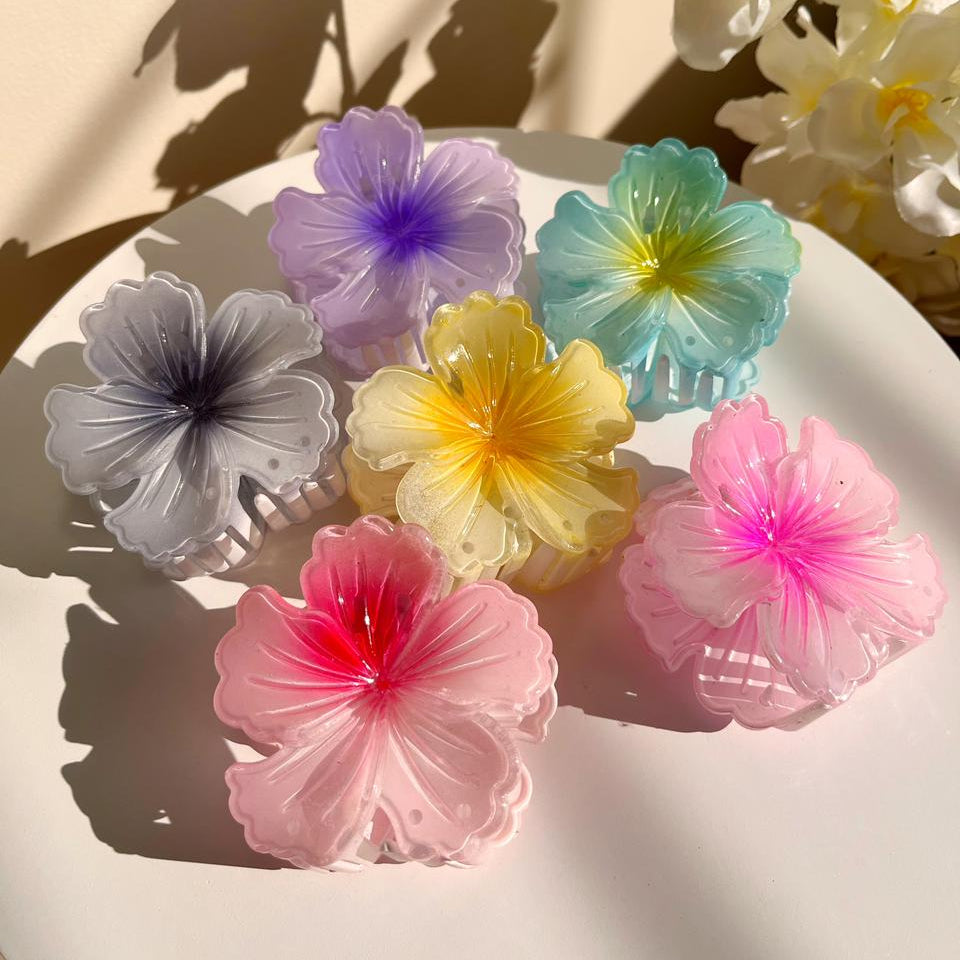 Colorful flower-shaped hair clips on a white surface with a beige background