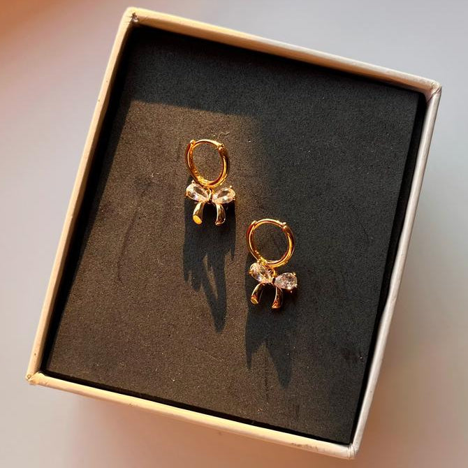 Gold earrings in a box on a blurred background