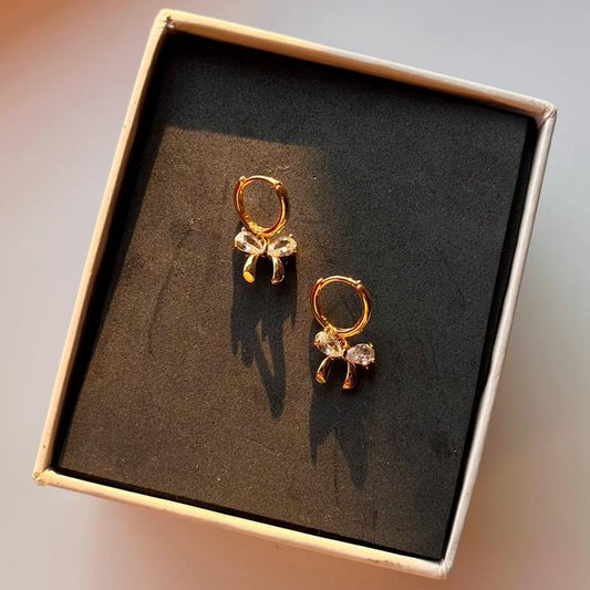Gold earrings in a box on a blurred background