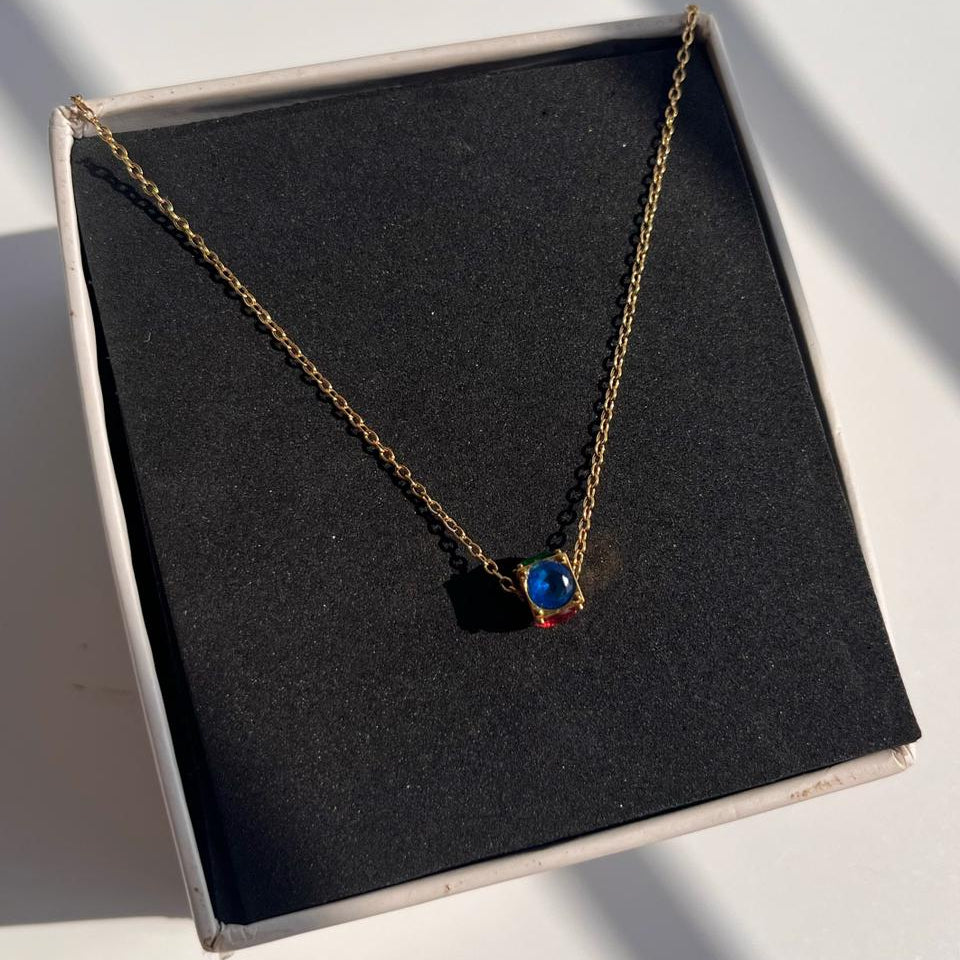 Necklace with a blue pendant on a black display box