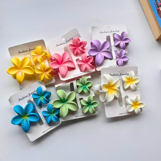 Set of colourful flower-shaped hair clips on white background. 