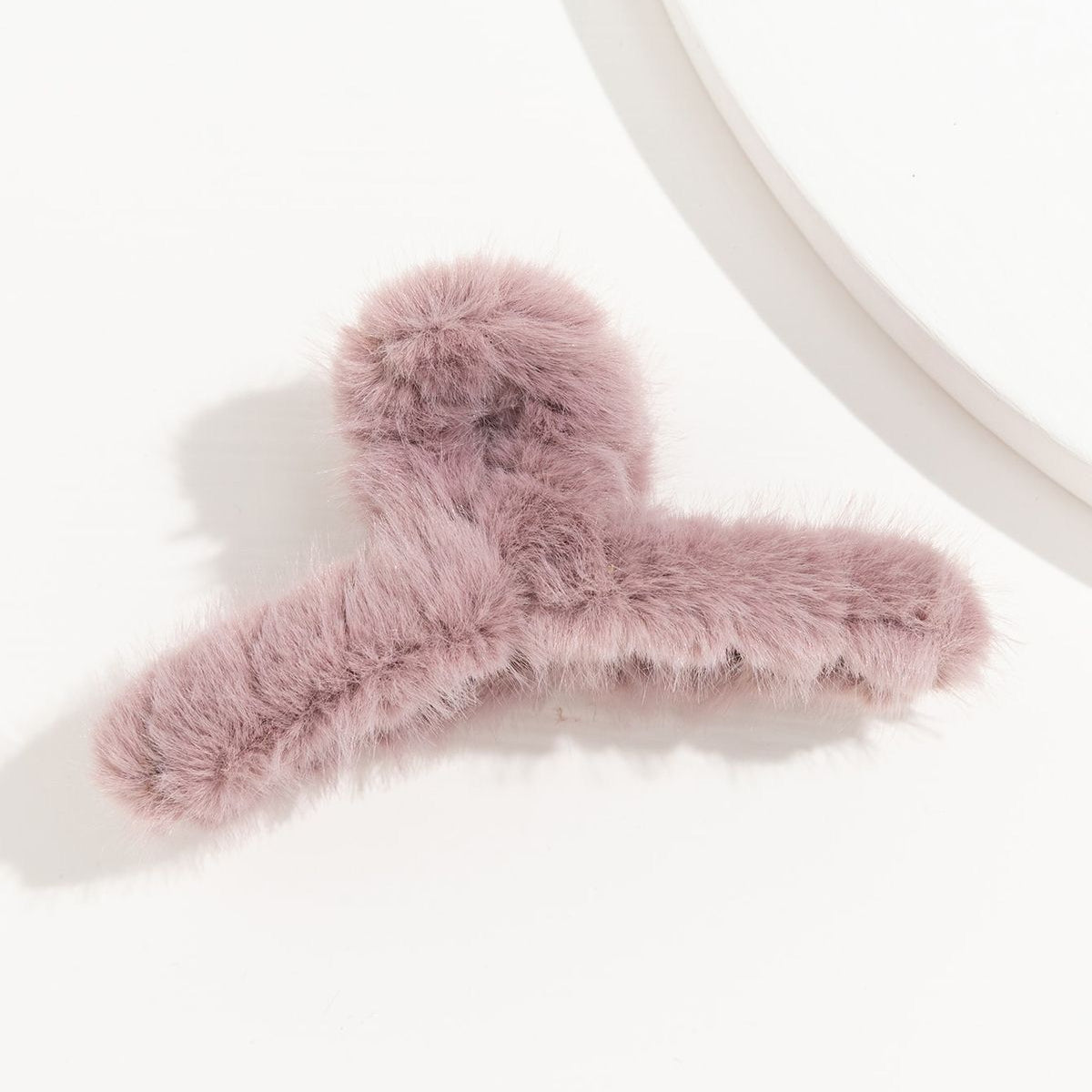 Pink fluffy hair clip on a white background
