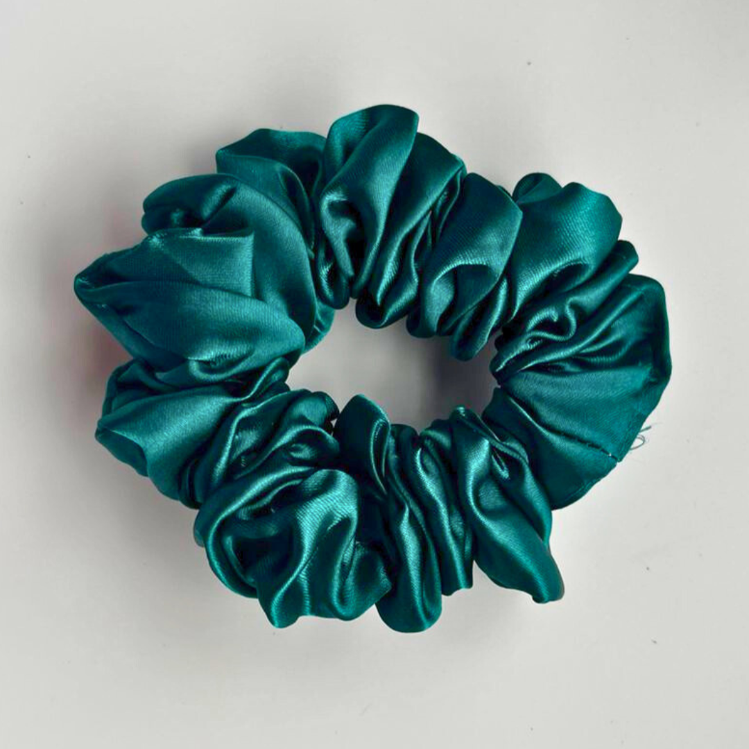 Teal satin scrunchie on a light gray background