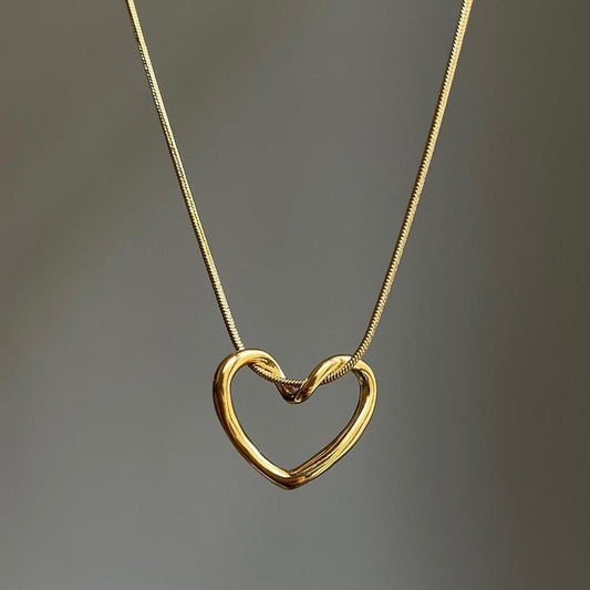 Gold heart-shaped necklace on a gray background