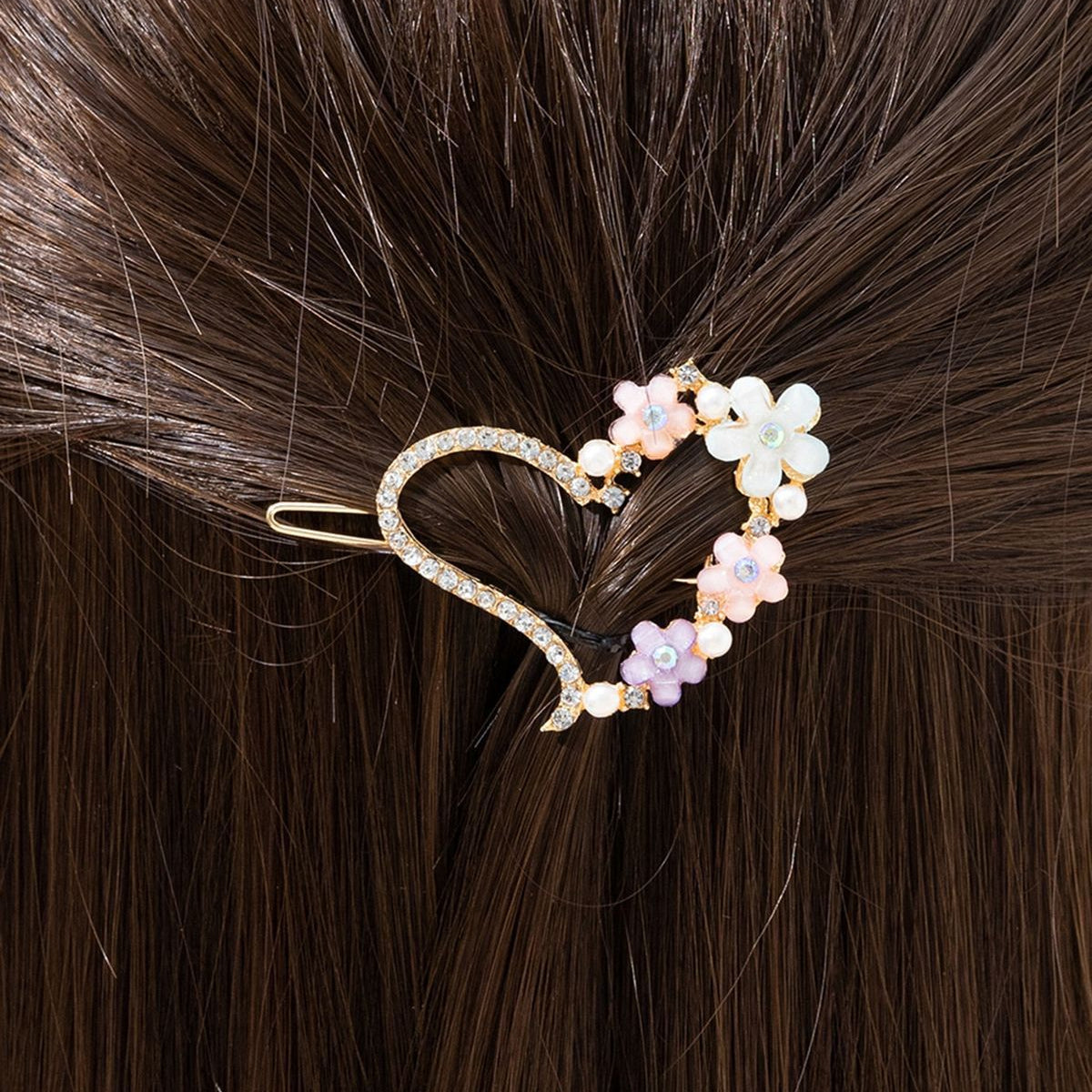 Heart-shaped hair clip with floral design in hair