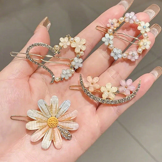 Hand holding decorative hair pins with floral designs on a neutral background