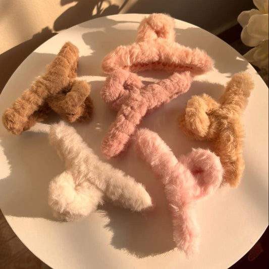 Fluffy Hair Clips on a white plate with a soft focus background