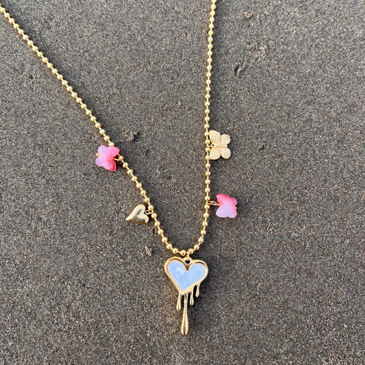 Necklace with heart and flower pendants on a textured surface