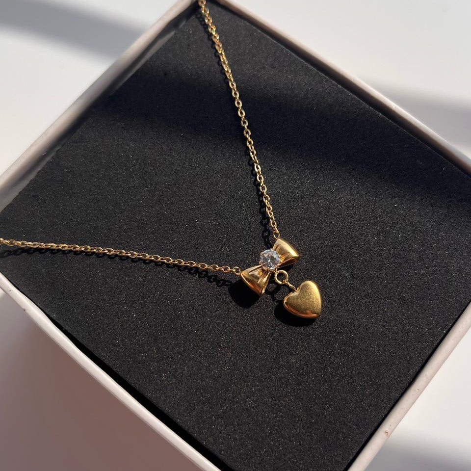 Gold necklace with heart pendants in a black jewelry box