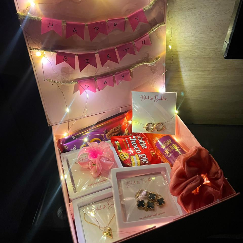 Gift box with jewelry and decorative lights on a dark background