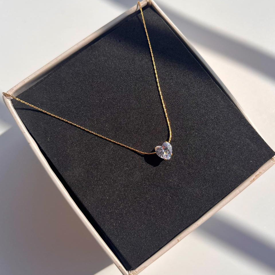 Necklace with a heart-shaped pendant on a black box