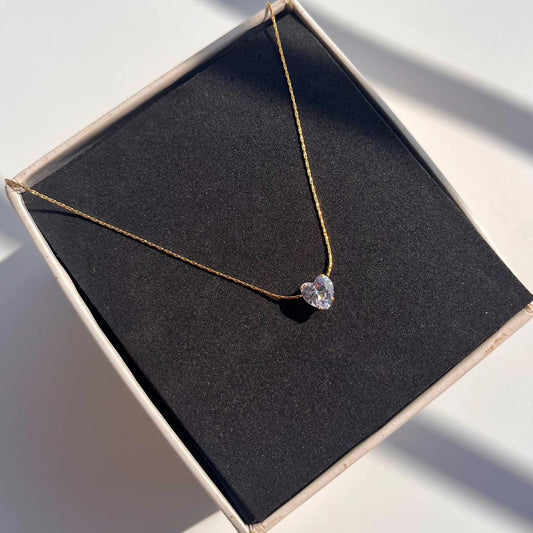 Necklace with a heart-shaped pendant on a black box