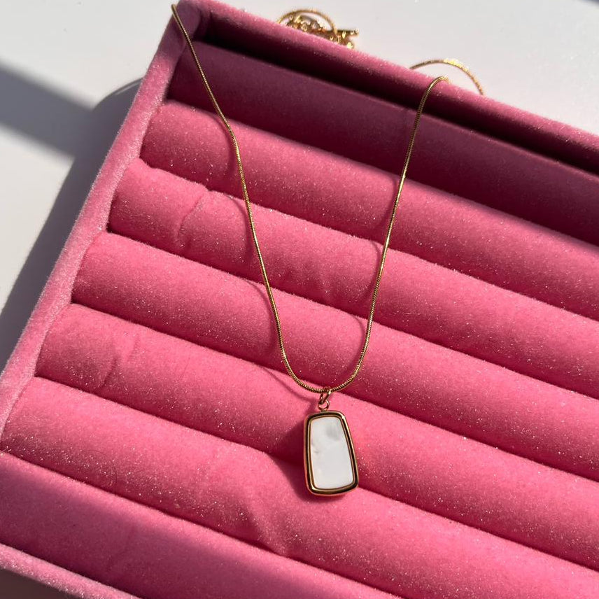 Necklace with a pendant on a pink jewelry box