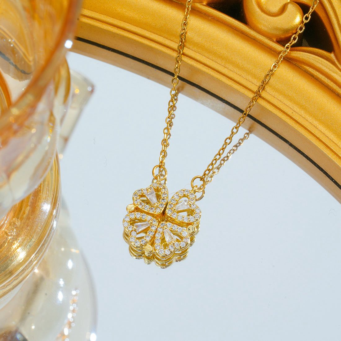 Gold necklace with a floral pendant on a decorative stand