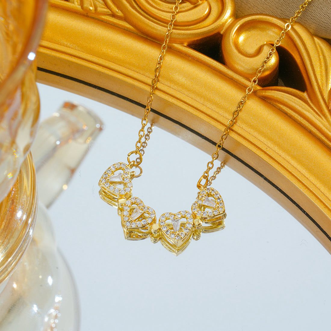 Gold necklace with heart-shaped pendants on a decorative background