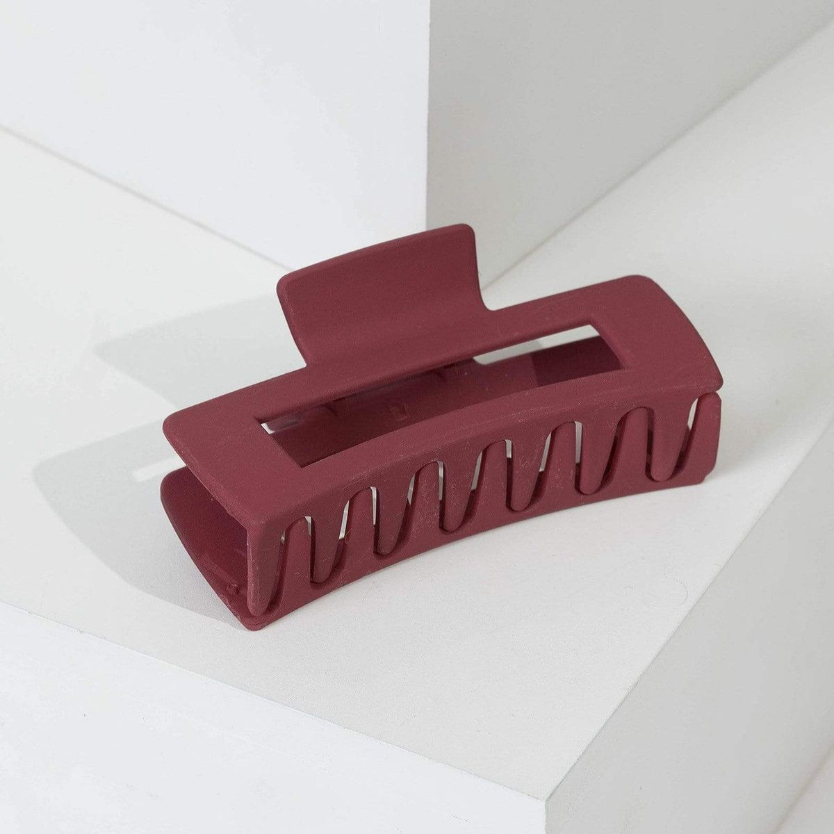 Maroon hair clip on a white background