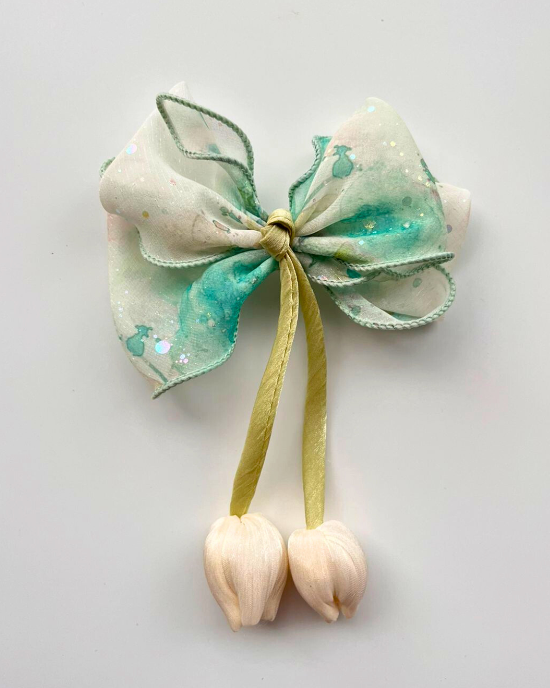 Decorative bow with green and white colors on a light gray background