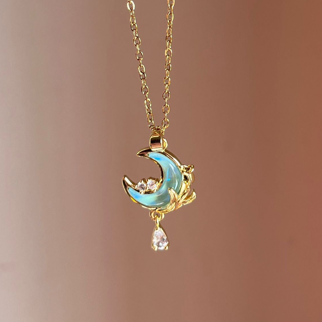 Delicate necklace with a moon and star pendant on a blurred background