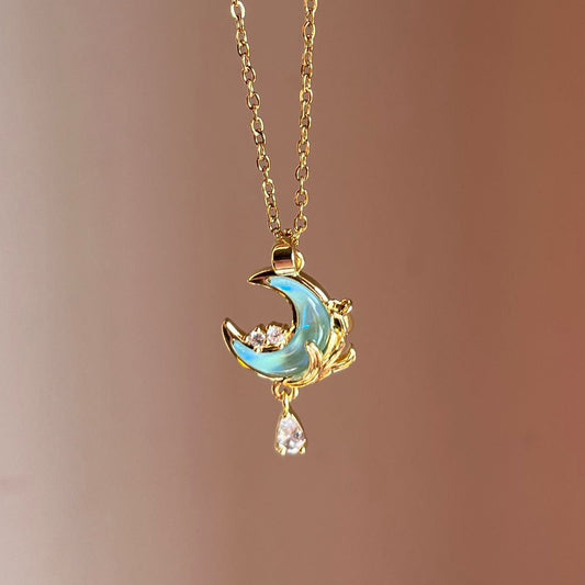 Delicate necklace with a moon and star pendant on a blurred background