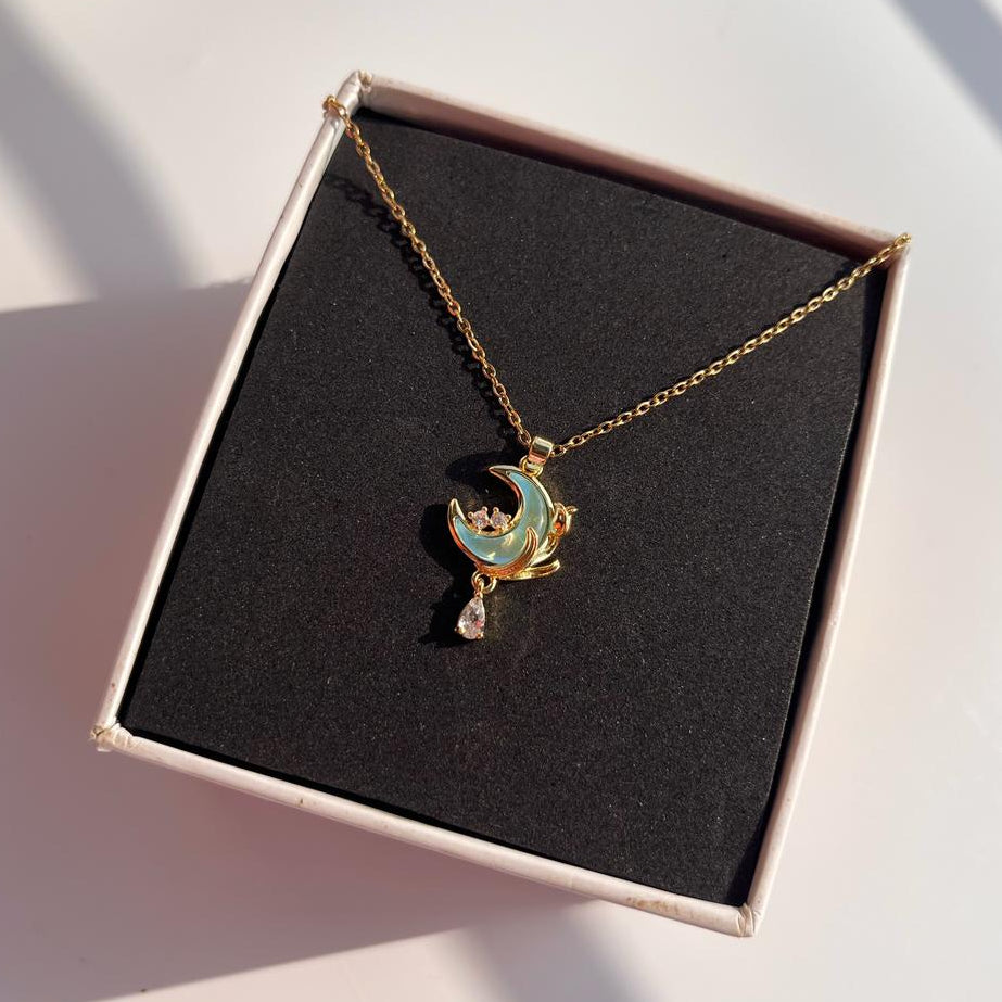 Necklace with a moon and star pendant in a box on a light background