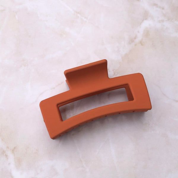 Orange hair clip on a marble surface